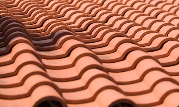 Detailed close-up of terracotta roof tiles, showcasing their wave-like pattern. - Photo by Jeffry Surianto on Pexels