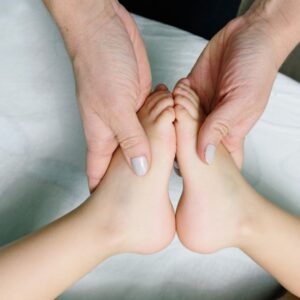 Adult hands gently massaging baby feet. Perfect representation of care and relaxation. - Photo by Ksenia Chernaya on Pexels