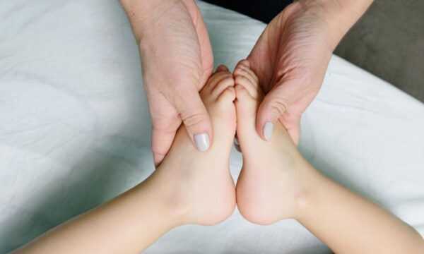 Adult hands gently massaging baby feet. Perfect representation of care and relaxation. - Photo by Ksenia Chernaya on Pexels